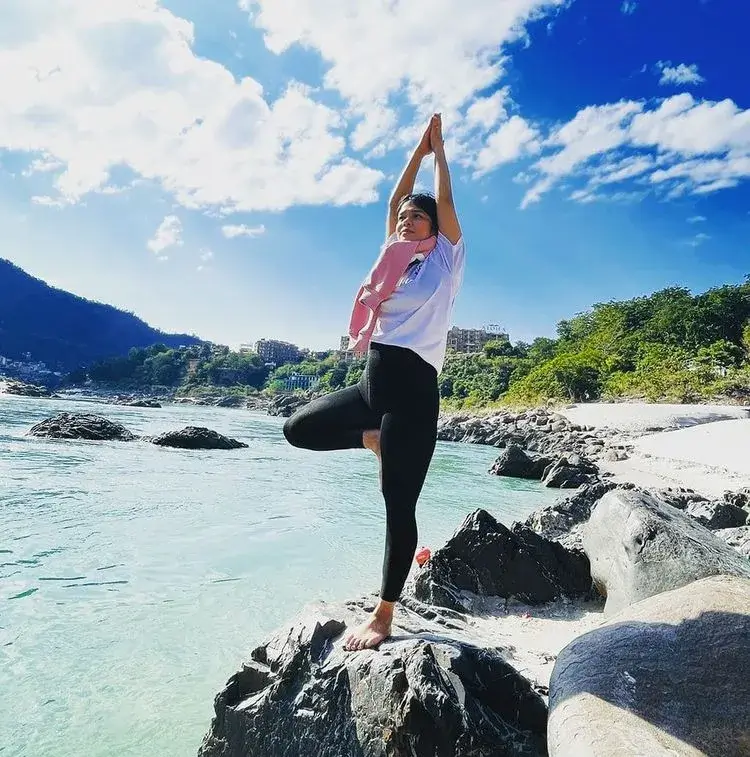 practicing vrikshasana near river ganga